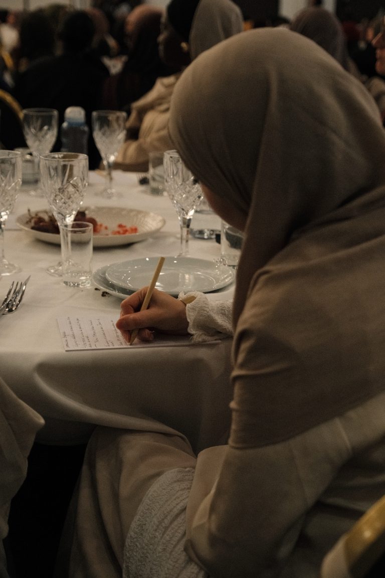 Une participante écrit à sa table pendant un temps de réflexion
